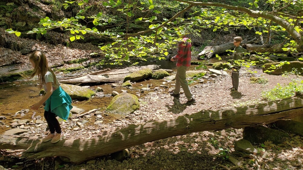 Family-Friendly hikes near Philadelphia - Father a two kids playing next to Potter Run Creek  onTyler Park's nature trail