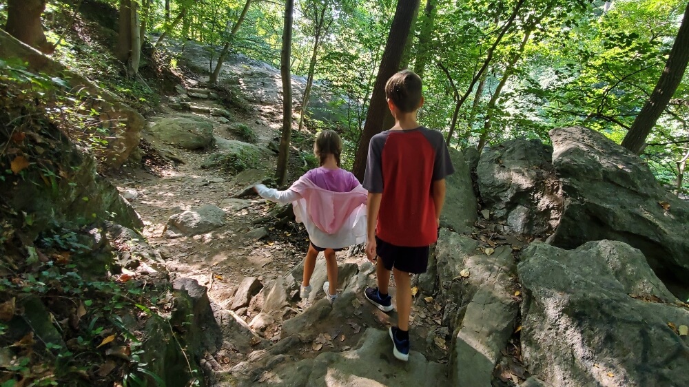 Family-Friendly hikes near Philadelphia. Kids hiking along the Orange Trail. navigating a rocky path, in Wissahickon Valley Park