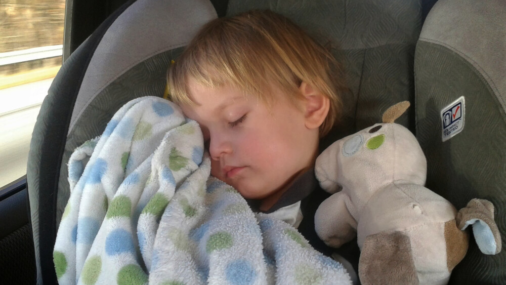 road trip tips for long car drives - sleeping with blanket and stuffed animal