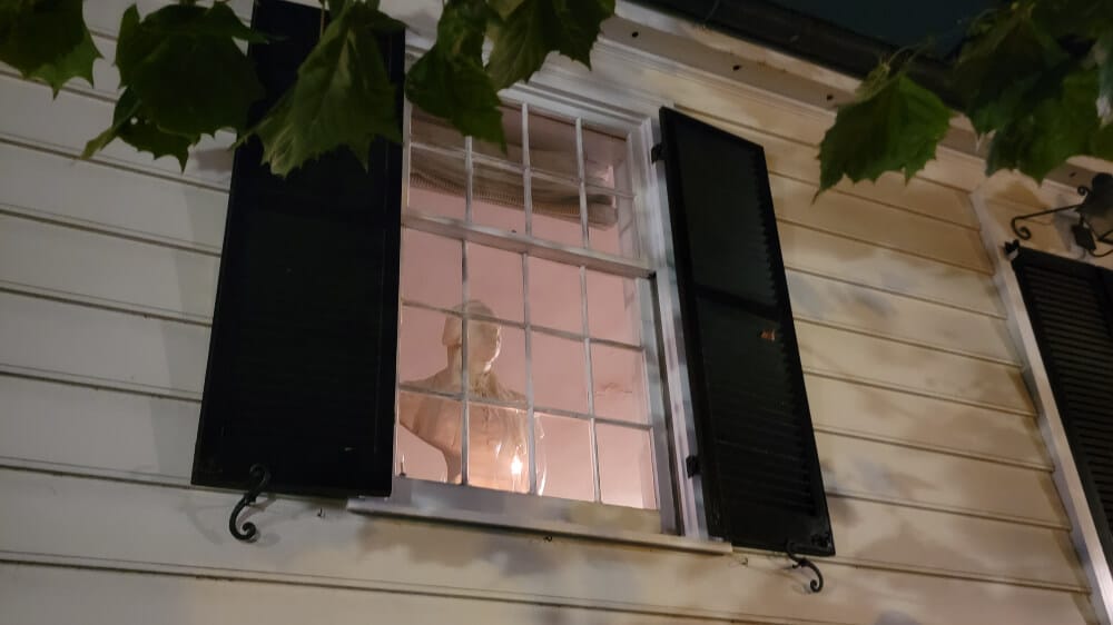 A bust of George Washington in a window seen at night on a ghost tour in Alexandria