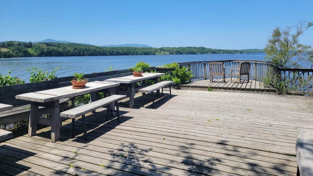 the riverdeck of the Saugerties lighthouse has multiple picnic tables and chairs to enjoy the views