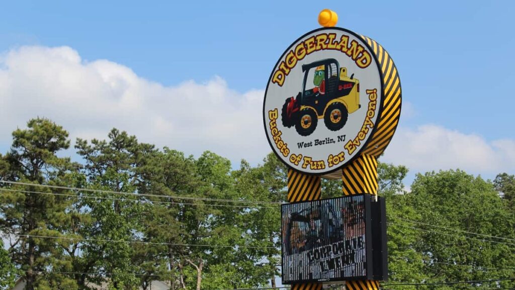 Circular sign with a construction truck and "diggerland" written on it