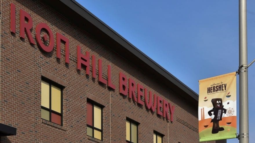 Iron Hill Brewery building with restaurant name in red and Hershey flag in foreground