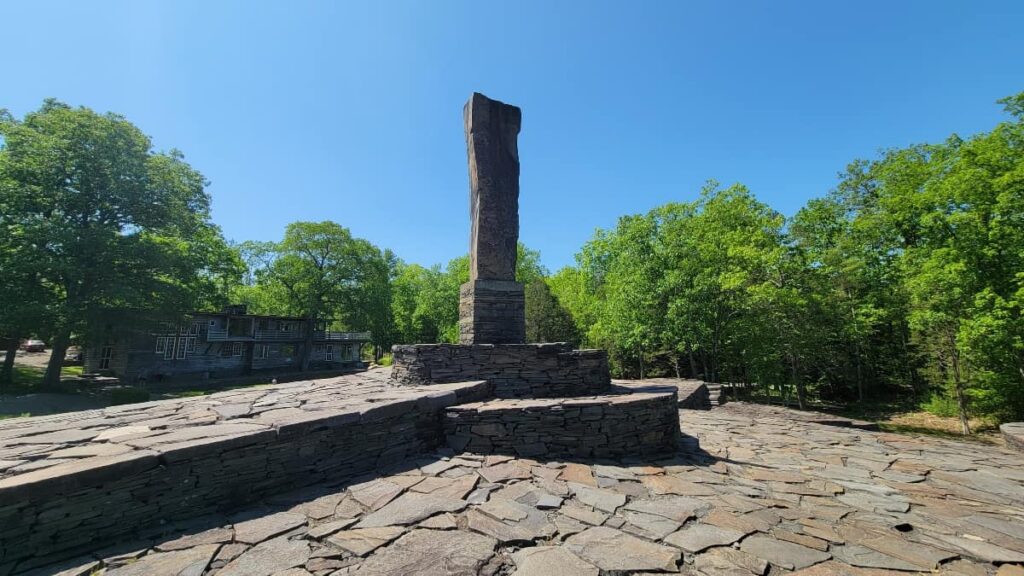 a monolith that is 13 feet tall weight 9 tons stands in the center of a blue stone platform