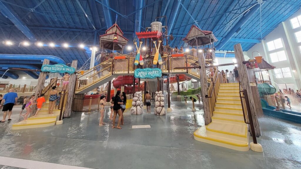 A large multi-level towers with water slides and sprayers sits inside Great Wolf Lodge indoor waterpark