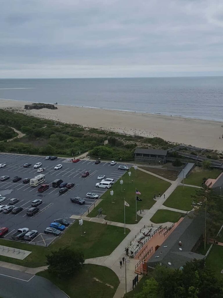 View of Cape May Point State Park parking lot, beach, and visitor center from the Cape May Lighthouse