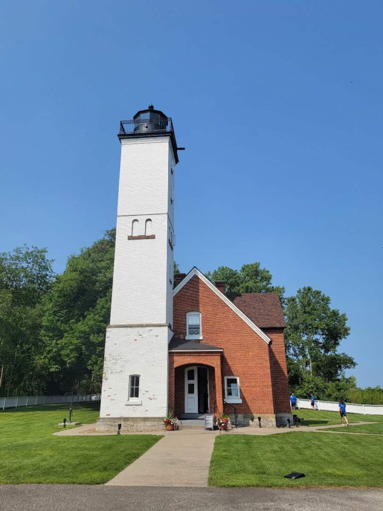 A red brick house with a white lighthouse tower to the left at Presque Isle State Park