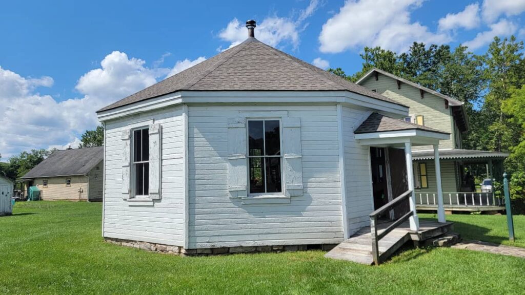 A white octagonal shaped building sits at Old Bedford Village 