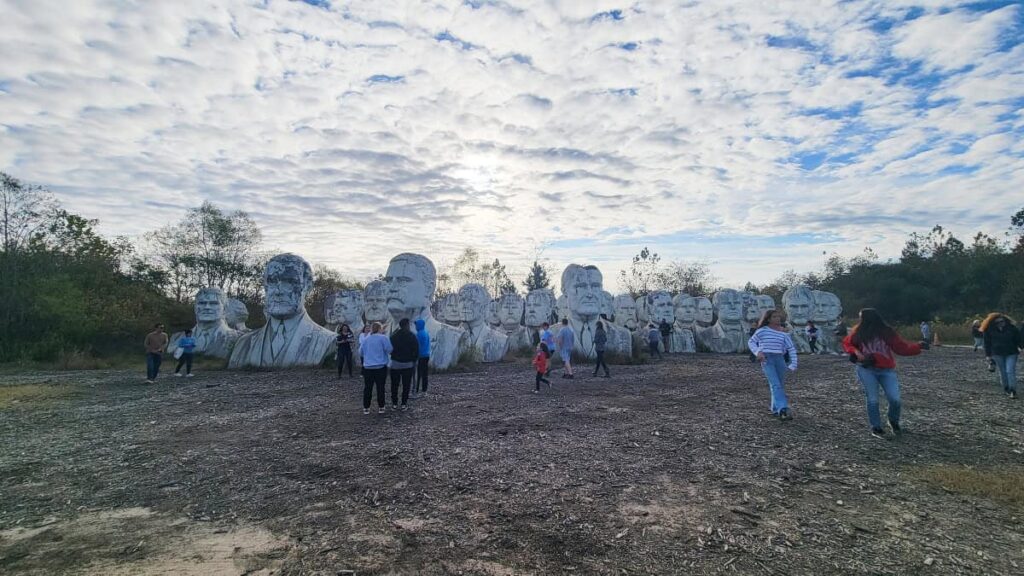 A group of presidential bust statues sit in an industrial recycling facility