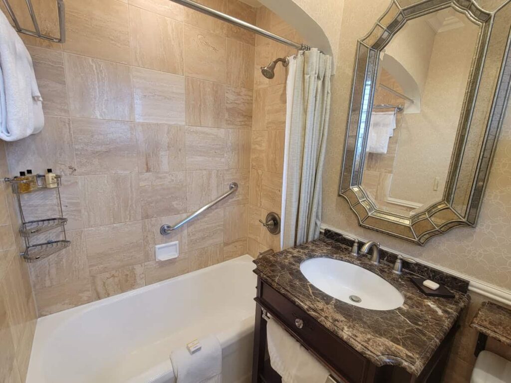 Looking at a small sink and tub inside a hotel room bathroom at the Hotel Hershey