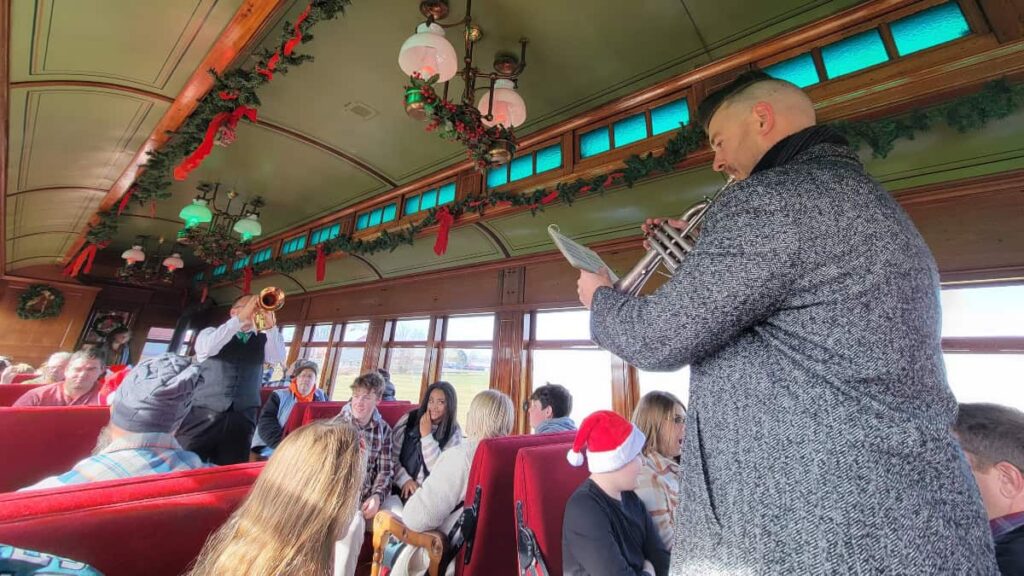 two musicians play christmas music on the train